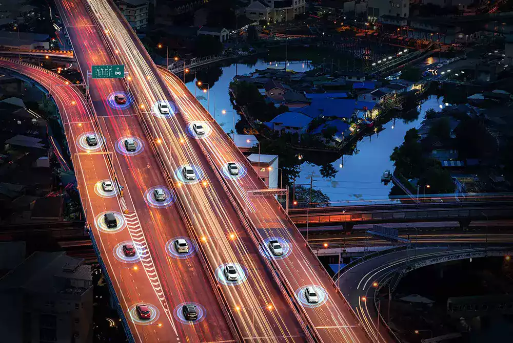 geolocalisation-flotte-vehicules-connectes-ocean.webp Vue aérienne d’une autoroute de nuit avec des véhicules connectés illustrant la géolocalisation et le suivi de flotte.