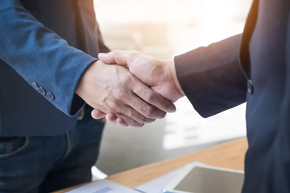 deux-hommes-affaires-confiants-se-serrant-main-lors-reunion-au-bureau-succes-traitement-salut-concept-partenaire copie