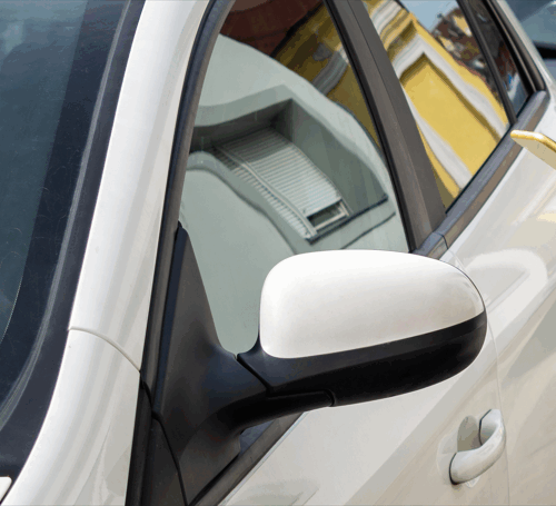 Personne utilisant son smartphone devant une voiture pour illustrer l’autopartage et la réservation d’un véhicule en entreprise.