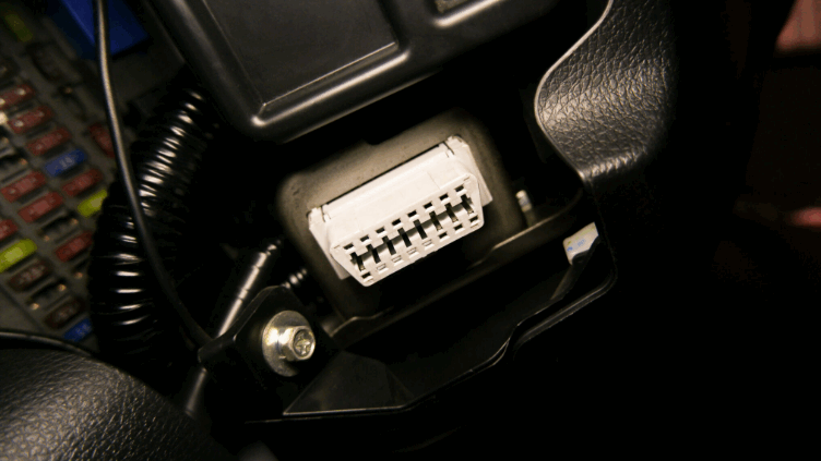 Vue rapprochée d’une prise OBD dans un véhicule, illustrant les méthodes d’installation des boîtiers de télématique embarquée via bus CAN et OBD.