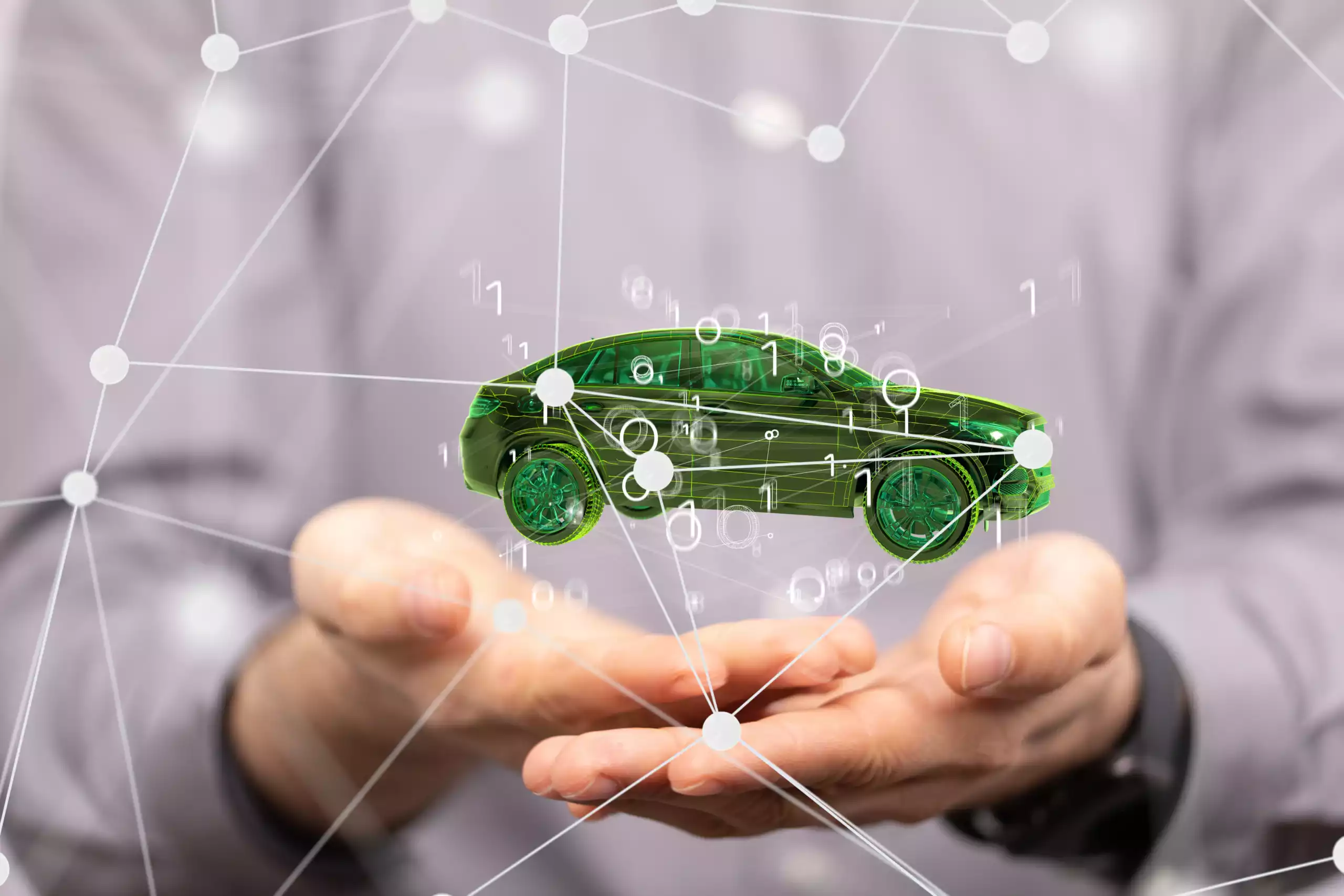 Voiture connectée symbolisée par un hologramme vert dans les mains d’un professionnel, représentant la maintenance prédictive et la gestion de flotte intelligente.