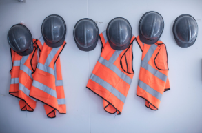 Professionnelle du BTP souriante tenant un casque de chantier, symbolisant l’évolution du secteur vers des pratiques plus technologiques et respectueuses de l’environnement.