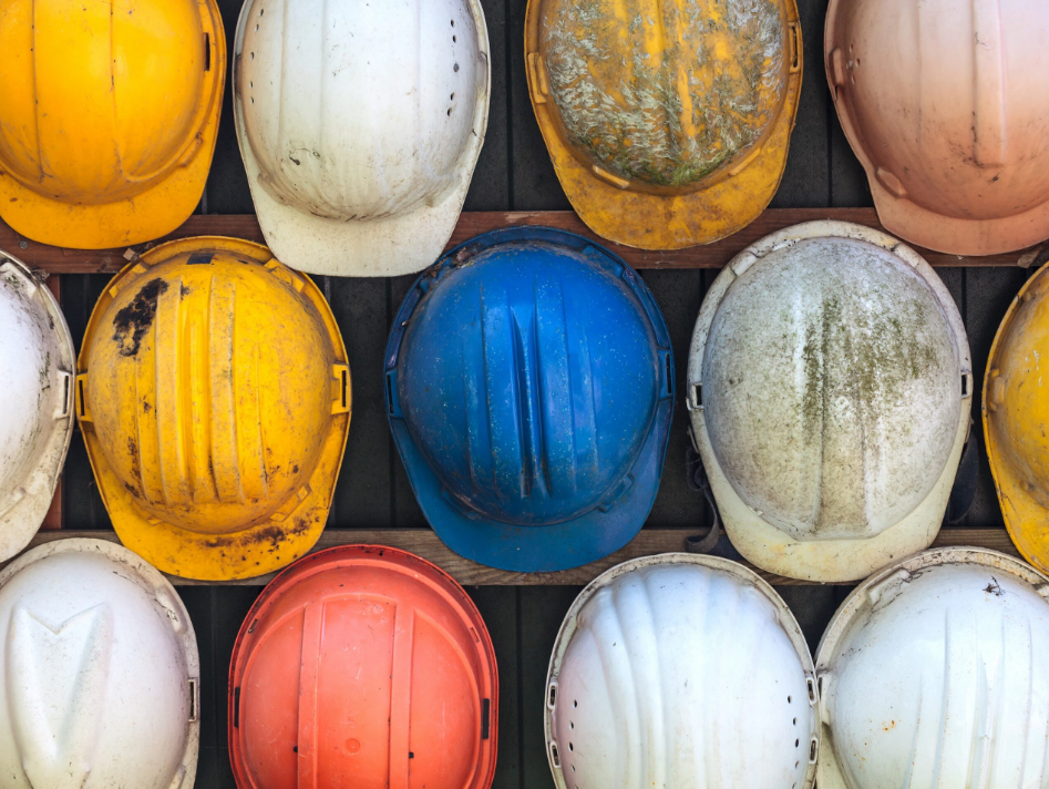 Casques de chantier colorés illustrant le secteur du BTP, accompagnant le dossier sur les avantages de la solution Océan pour les entreprises de construction.