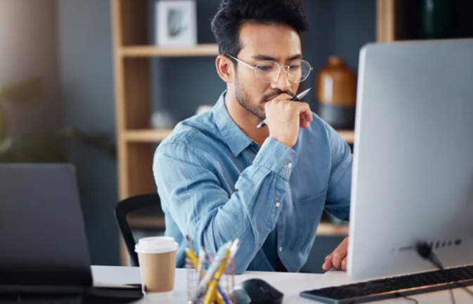 Homme travaillant sur ordinateur, illustrant une réflexion sur l’autopartage et la gestion de flotte en entreprise.