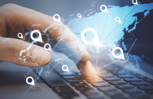 Main utilisant un clavier avec une carte numérique et des points de géolocalisation représentant la gestion et le suivi d’une flotte de véhicules.