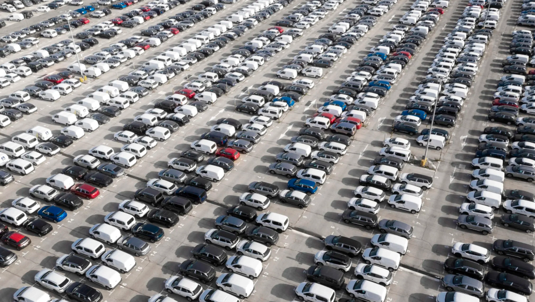 Vue aérienne d’un grand parking de véhicules d’entreprise illustrant la gestion et le suivi du taux d’utilisation d’une flotte automobile.