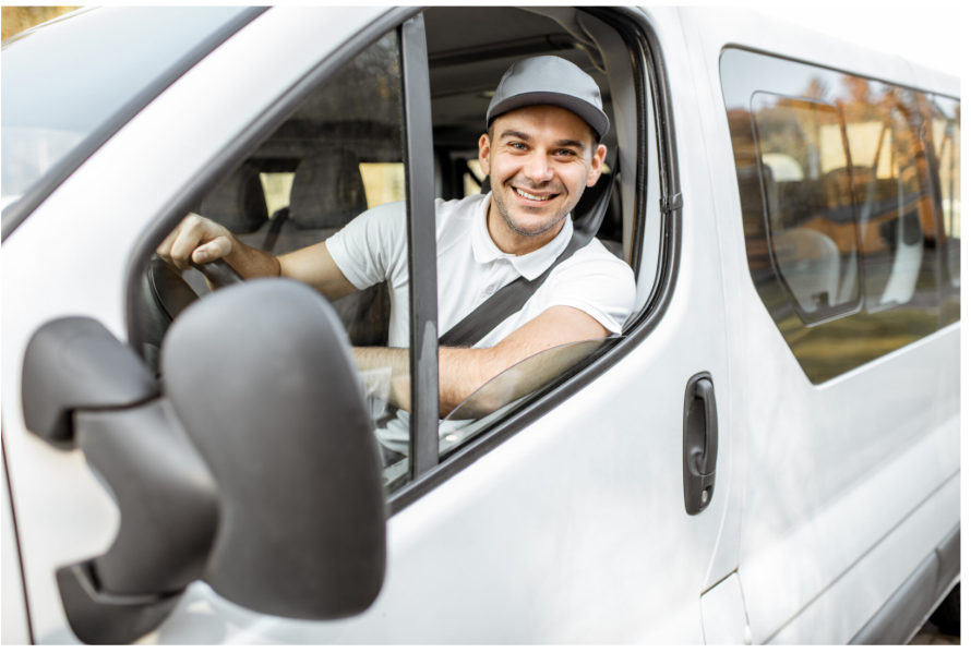 Conducteur souriant au volant d’un véhicule utilitaire, illustrant la mise en place d’une démarche d’écoconduite et d’identification conducteur dans une flotte automobile.