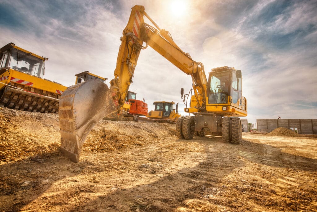 Pelleteuse et engins de chantier sur un site de construction, illustrant la gestion de flotte dans le secteur du BTP.