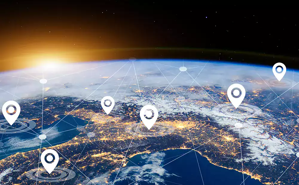 Vue satellite de la Terre avec des repères de géolocalisation connectés, illustrant la gestion internationale de flotte et le suivi des véhicules en temps réel.