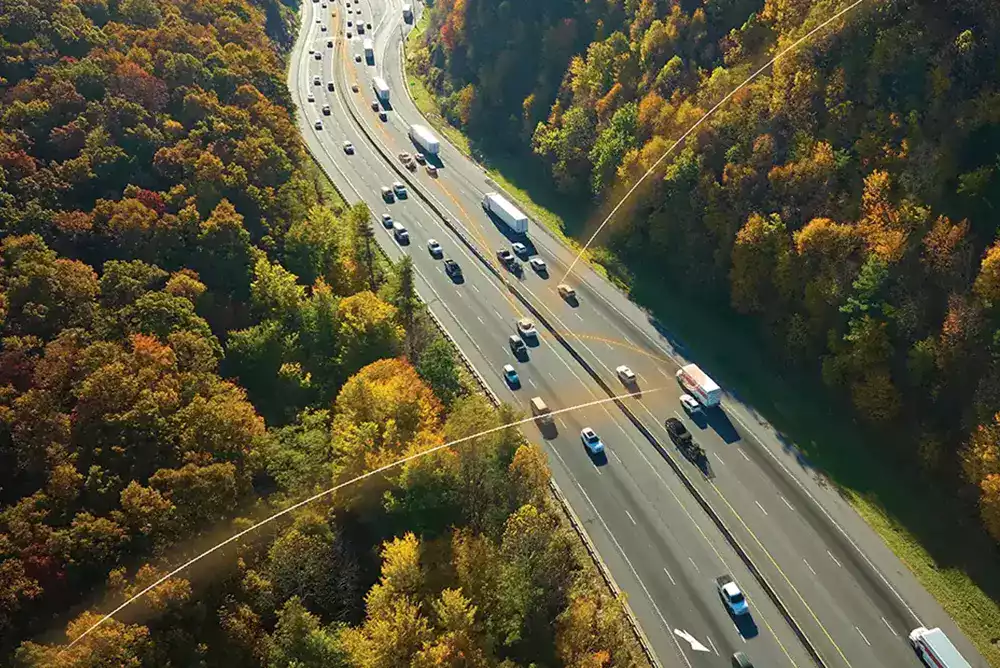 Vue aérienne d’une autoroute avec des véhicules connectés illustrant la géolocalisation en temps réel.