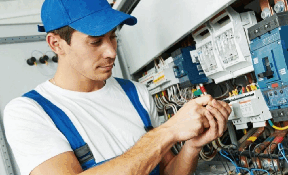 Technicien de maintenance travaillant sur une installation électrique, illustrant les solutions de gestion de flotte et d’activité proposées par Océan pour les métiers d’intervention.