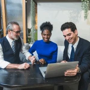 convaincre-collaborateurs-transition-vehicules-electriques.webp Équipe de collaborateurs échangeant autour d’un ordinateur sur la transition vers la mobilité électrique en entreprise.