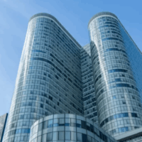 obligations-entreprises-flottes-vehicules-faibles-emissions.webp Immeuble de bureaux moderne représentant les entreprises concernées par les obligations de verdissement de leur flotte de véhicules.