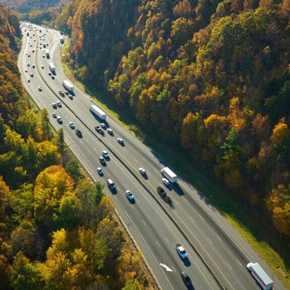 flotte-multi-vehicules-donnees-reelles-o-direct-ocean.jpg Vue aérienne d’une autoroute traversant une forêt, illustrant la gestion et l’optimisation d’une flotte multi-véhicules grâce aux données réelles O-Direct.