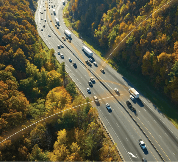 Vue aérienne de véhicules sur route illustrant la géolocalisation et la gestion de flotte.