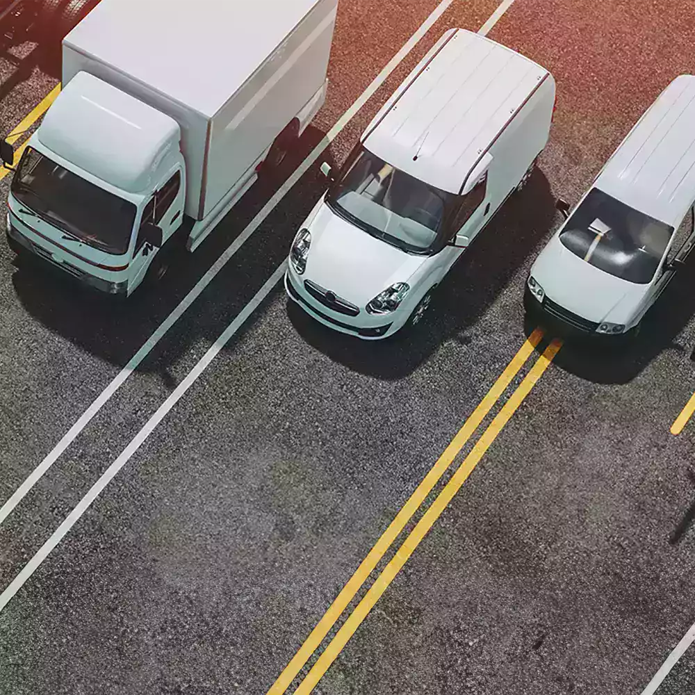 gestion-flotte-vehicules-utilitaires-ocean.webp (1)-min-min Véhicules utilitaires alignés sur une route, illustrant la gestion et l’organisation d’une flotte d’entreprise.